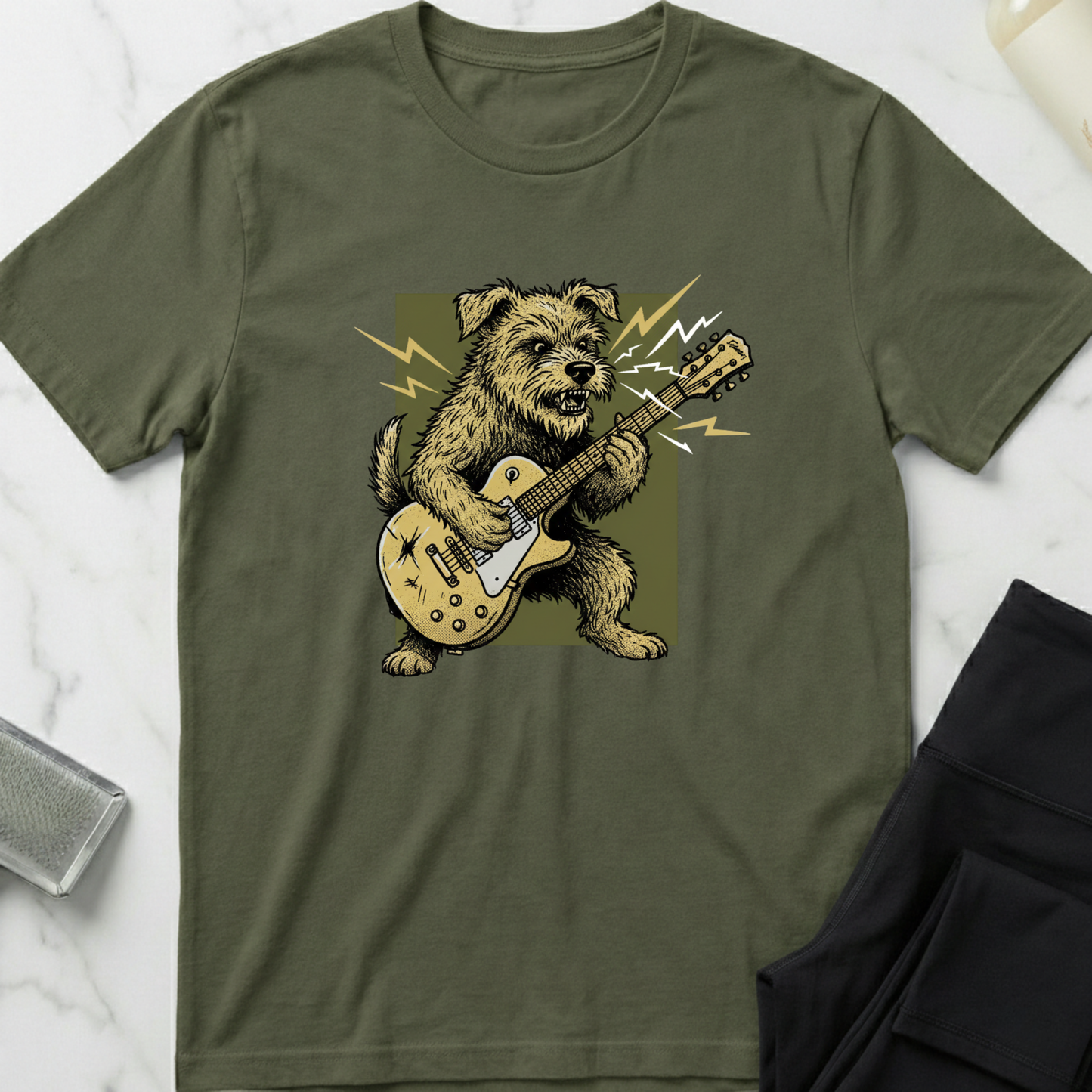 Green t-shirt with a dog playing guitar graphic on a marble surface. Minimalist dog apparel by pemuyo.