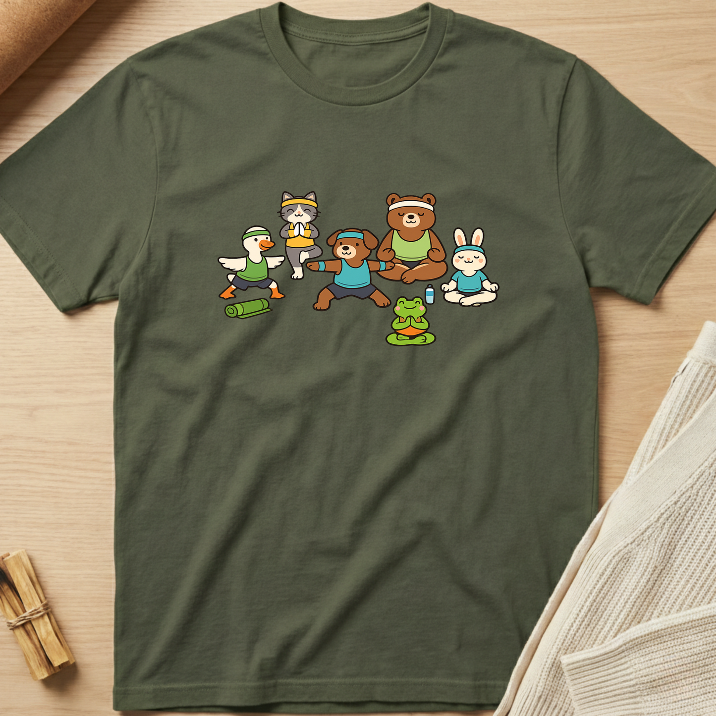 Green t-shirt with cartoon characters on a wooden surface. Minimalist yoga apparel by pemuyo.