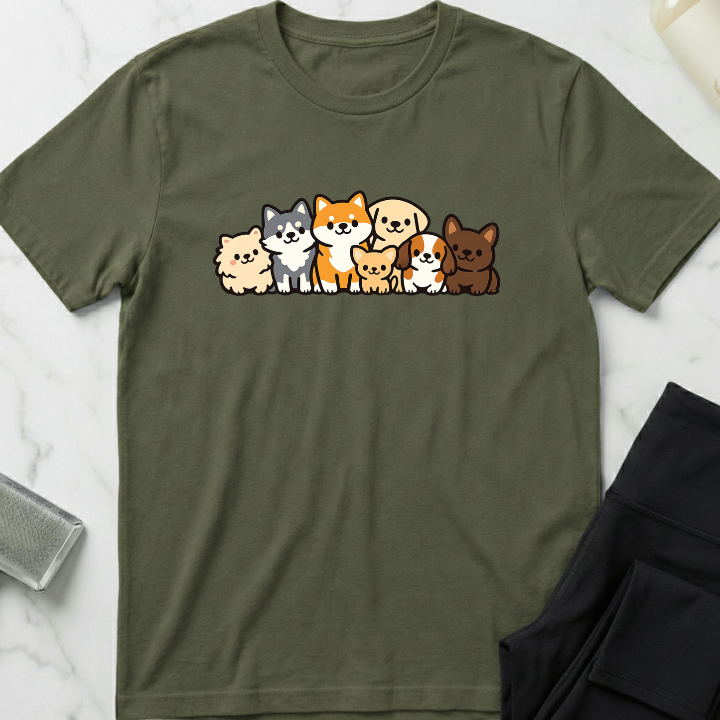 Green t-shirt with cartoon dog illustrations on a white marble surface. Minimalist dog apparel by pemuyo.