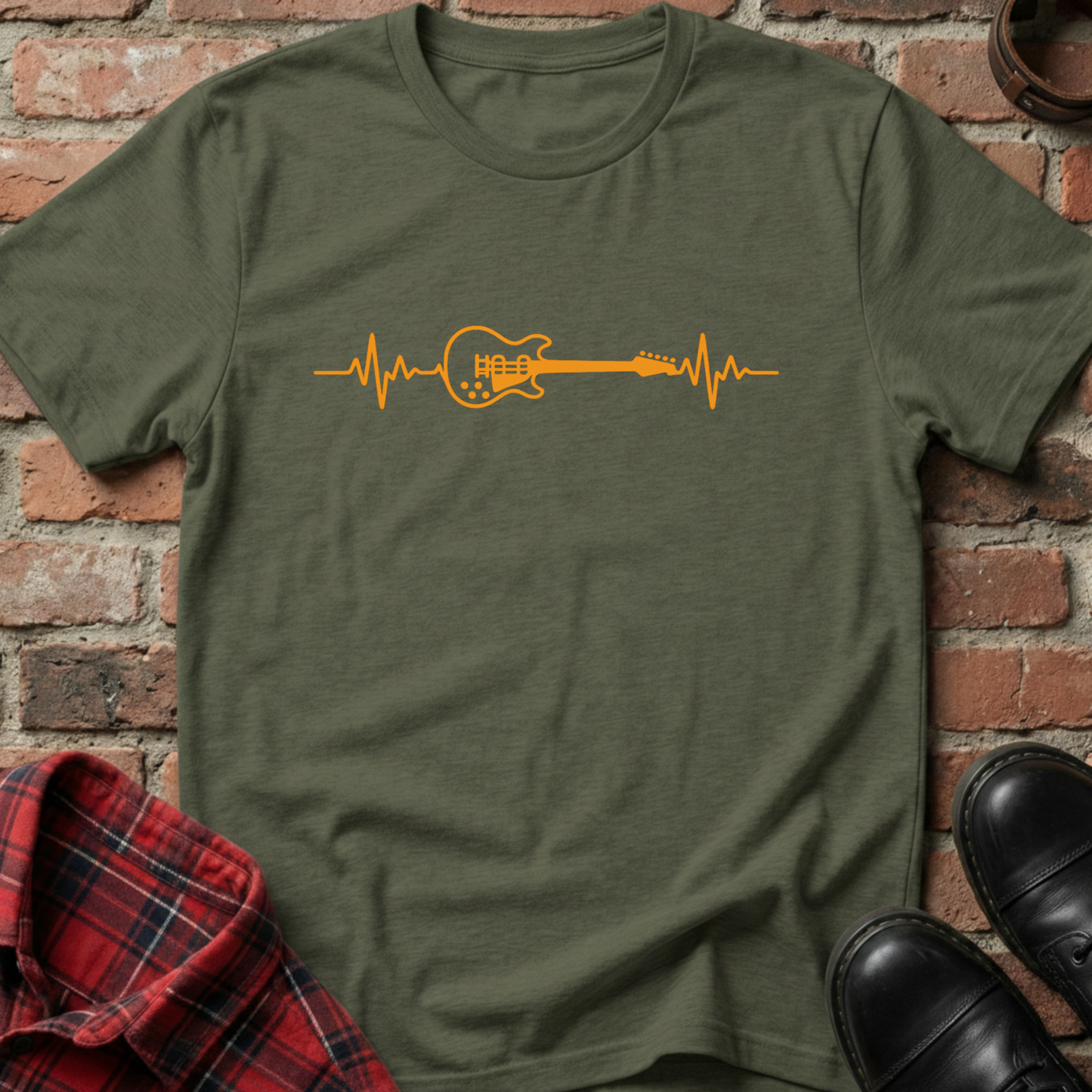 Green t-shirt with orange guitar heartbeat design on a brick background. Minimalist music apparel by pemuyo.