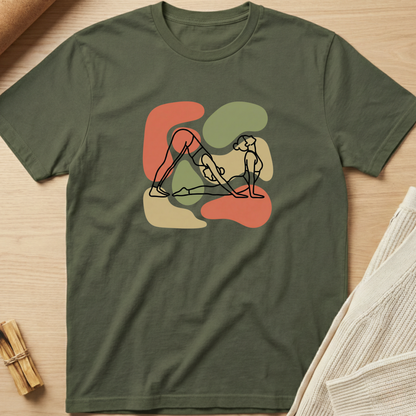 Green t-shirt with abstract design on a wooden surface. Minimalist yoga apparel by pemuyo.