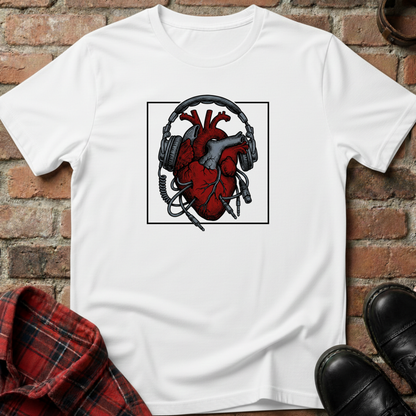 White t-shirt with a red heart and black headphones graphic on a brick surface. Minimalist music apparel by pemuyo.