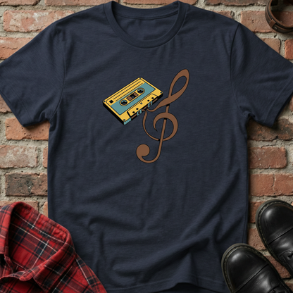Navy blue t-shirt with a cassette tape and music note design against a brick wall. Minimalist music apparel by pemuyo.