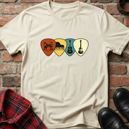 Beige t-shirt with musical instrument picks design on a brick wall background. Minimalist music apparel by pemuyo.