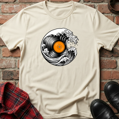 Beige t-shirt with vinyl record design on a brick wall background. Minimalist music apparel by pemuyo.