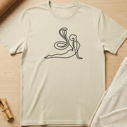 Beige t-shirt with a black line art design of a person in a yoga pose on a wooden surface. Minimalist yoga apparel by pemuyo.
