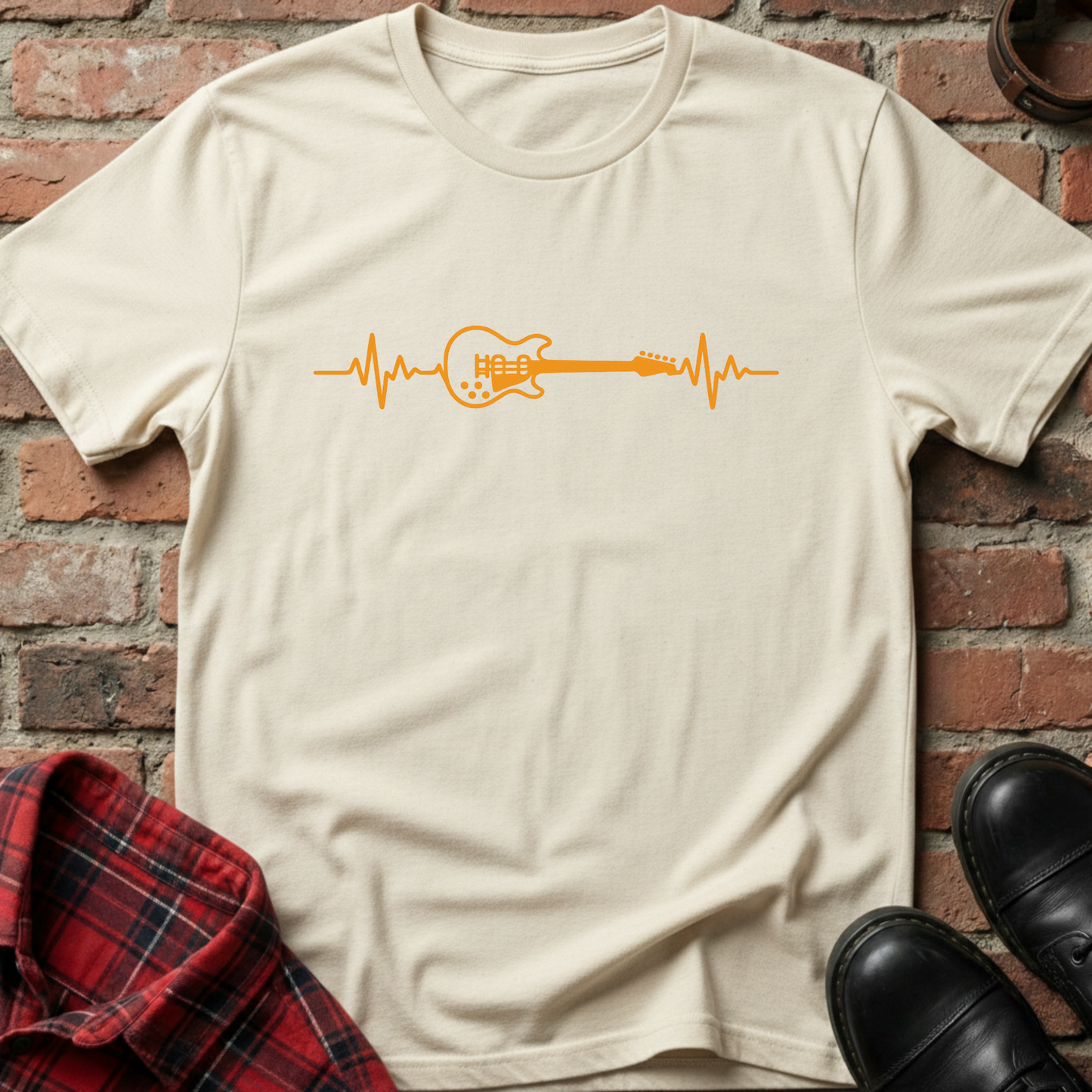 Beige t-shirt with orange guitar heartbeat design on a brick wall background. Minimalist music apparel by pemuyo.