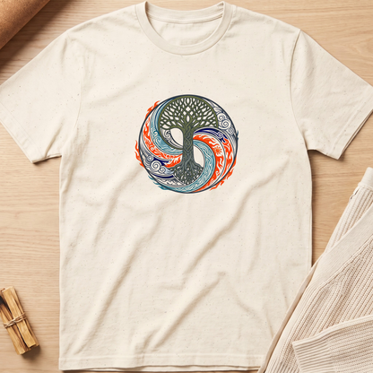 An off-white short-sleeve t-shirt with a circular 'Tree of Life' yin-yang style graphic in blue, orange, and green, laid flat on a light wood background with a knit blanket and small wooden sticks nearby. Minimalist yoga apparel by pemuyo.