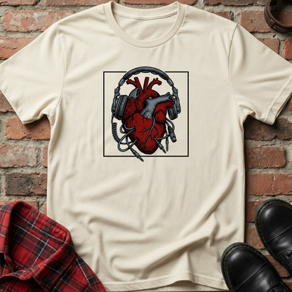 Beige t-shirt with a graphic of a heart with headphones against a brick wall. Minimalist music apparel by pemuyo.