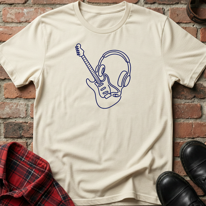 Beige t-shirt with a blue graphic design of a guitar and headphones on a brick surface. Minimalist music apparel by pemuyo.
