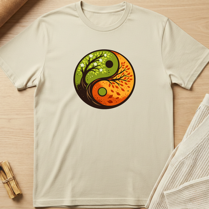 Beige t-shirt with a yin yang design featuring nature elements on a wooden surface. Minimalist yoga apparel by pemuyo.