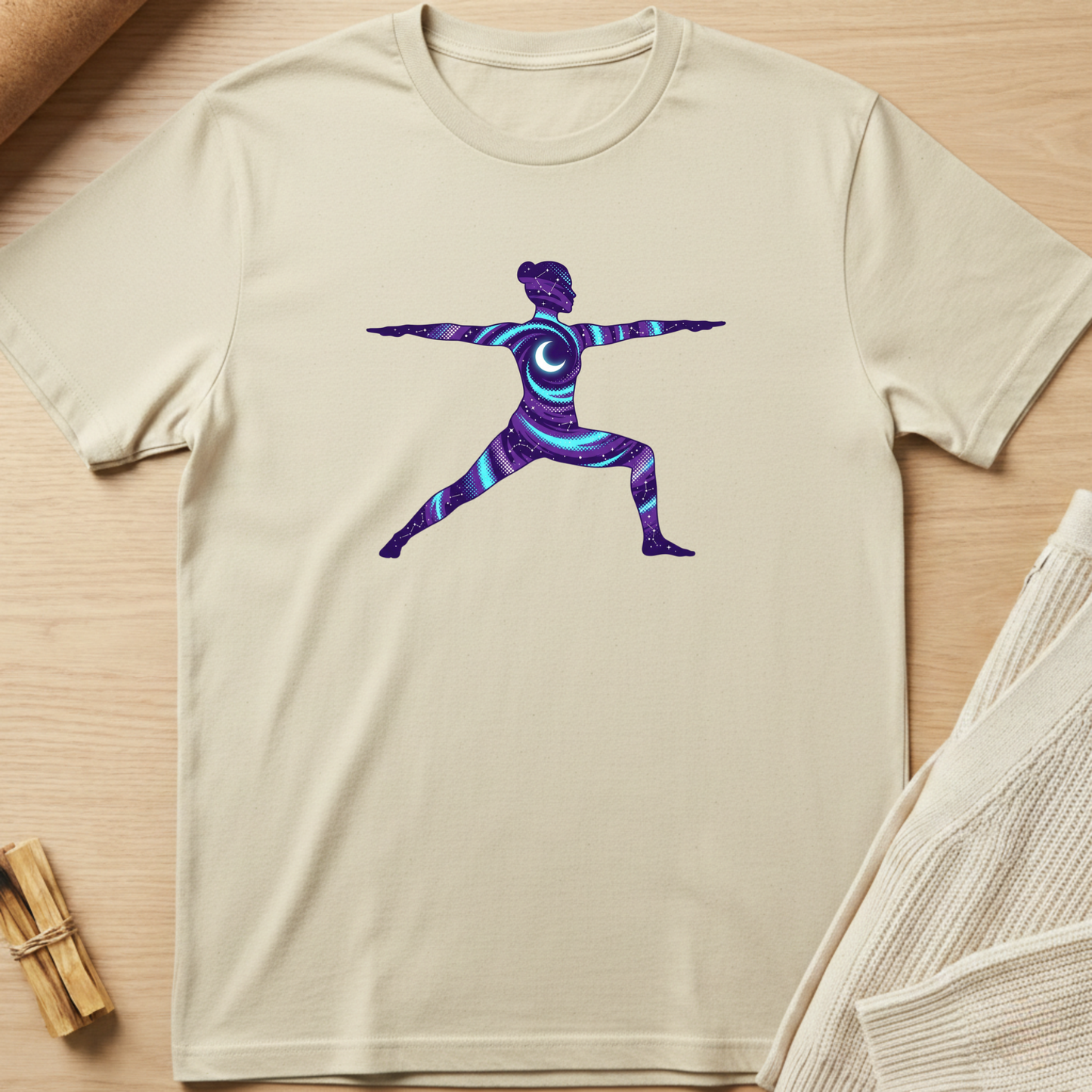 Beige t-shirt with a colorful yoga pose design on a wooden surface. Minimalist yoga apparel by pemuyo.