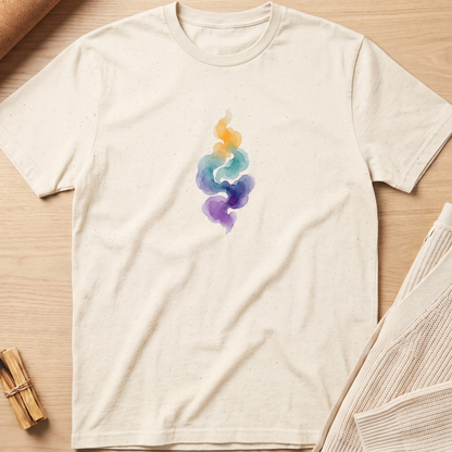 An off-white short-sleeve t-shirt with a colorful watercolor design of a stylized smoke or flame motif in yellow, teal, blue, and purple on the chest, laid flat on a light wood background. Minimalist yoga apparel by pemuyo.