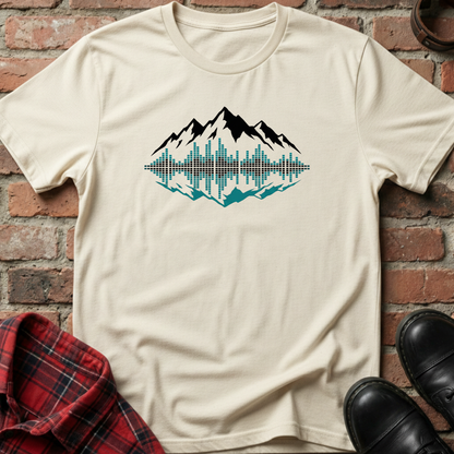 Beige t-shirt with mountain graphic design on a brick surface. Minimalist music apparel by pemuyo.