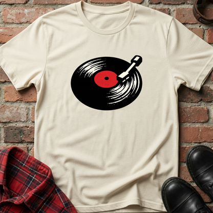 Beige t-shirt with a vinyl record design on a brick wall background. Minimalist music apparel by pemuyo.