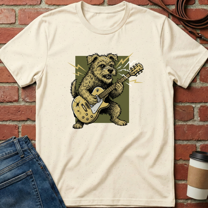Beige t-shirt with a graphic of a dog playing a guitar on a brick wall background. Minimalist dog apparel by pemuyo.