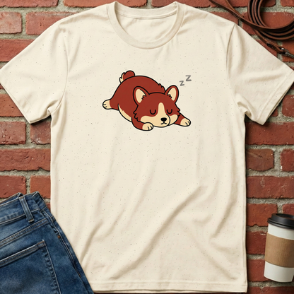 Beige t-shirt with a cartoon dog design on a brick wall background. Minimalist dog apparel by pemuyo.