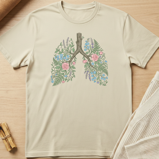 Beige t-shirt with floral lung design on a wooden surface. Minimalist yoga apparel by pemuyo.