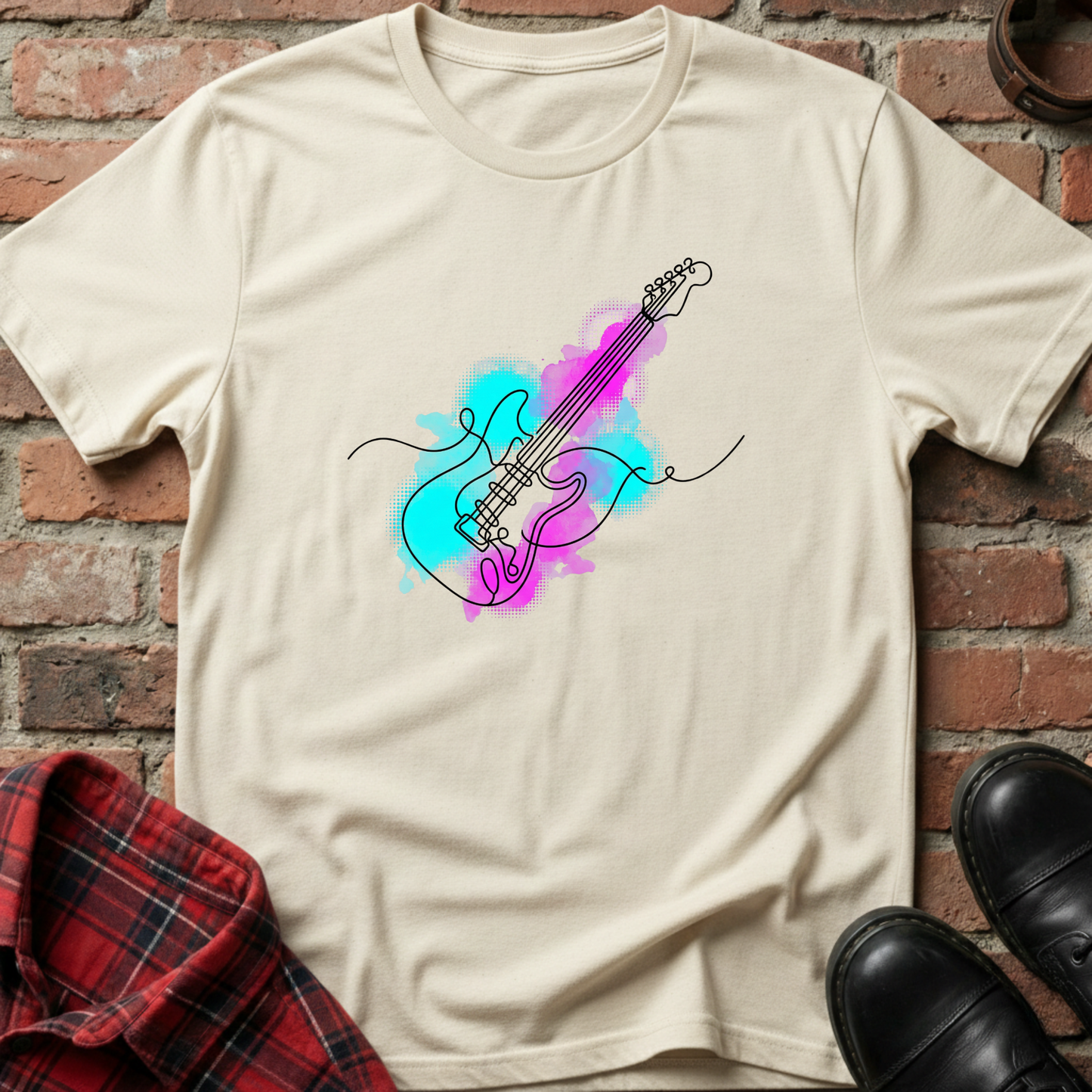 Beige t-shirt with a colorful guitar design on a brick wall background. Minimalist music apparel by pemuyo.