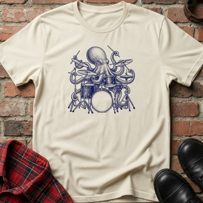 Beige t-shirt with an octopus playing drums graphic on a brick wall background. Minimalist music apparel by pemuyo.