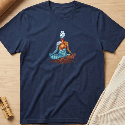 A navy blue short-sleeve t-shirt laid flat on a light wood surface, featuring a colorful graphic of a meditating figure with blue, orange, and red details. The shirt is styled with a beige knit fabric and small wooden sticks in the corners. Minimalist yoga apparel by pemuyo.