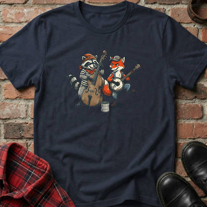 Navy blue t-shirt with raccoon and fox playing instruments on a brick wall background. Minimalist music apparel by pemuyo.