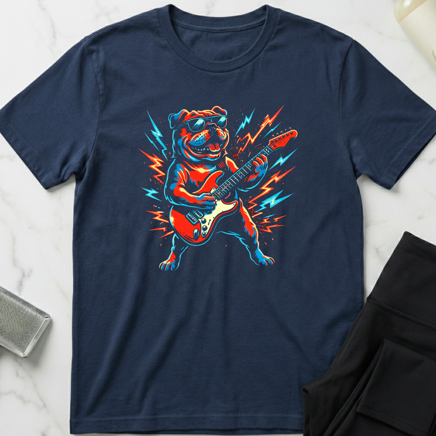 Navy blue t-shirt with a dog playing guitar graphic on a marble surface. Minimalist dog apparel by pemuyo.