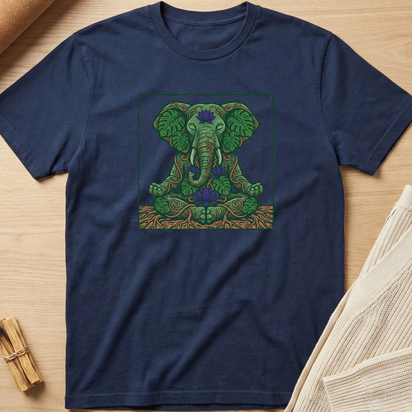 Navy blue t-shirt with a green elephant design on a wooden surface. Minimalist yoga apparel by pemuyo.