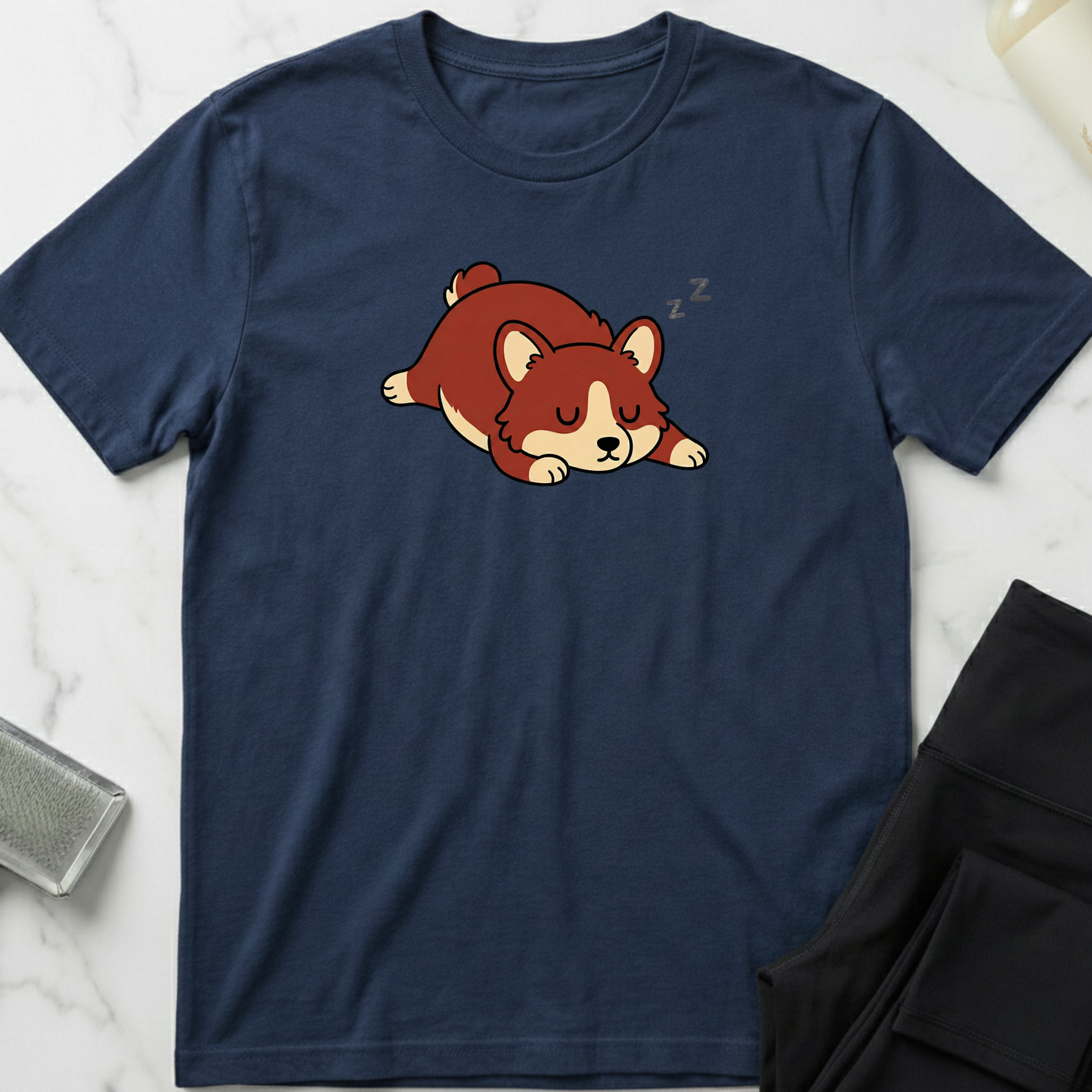 Navy blue t-shirt with a cartoon dog design on a marble surface. Minimalist dog apparel by pemuyo.