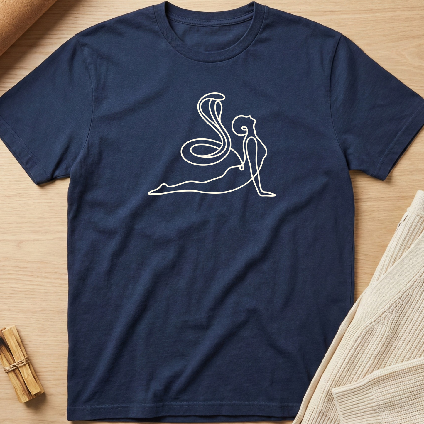 Navy blue t-shirt with white line art design on a wooden surface. Minimalist yoga apparel by pemuyo.