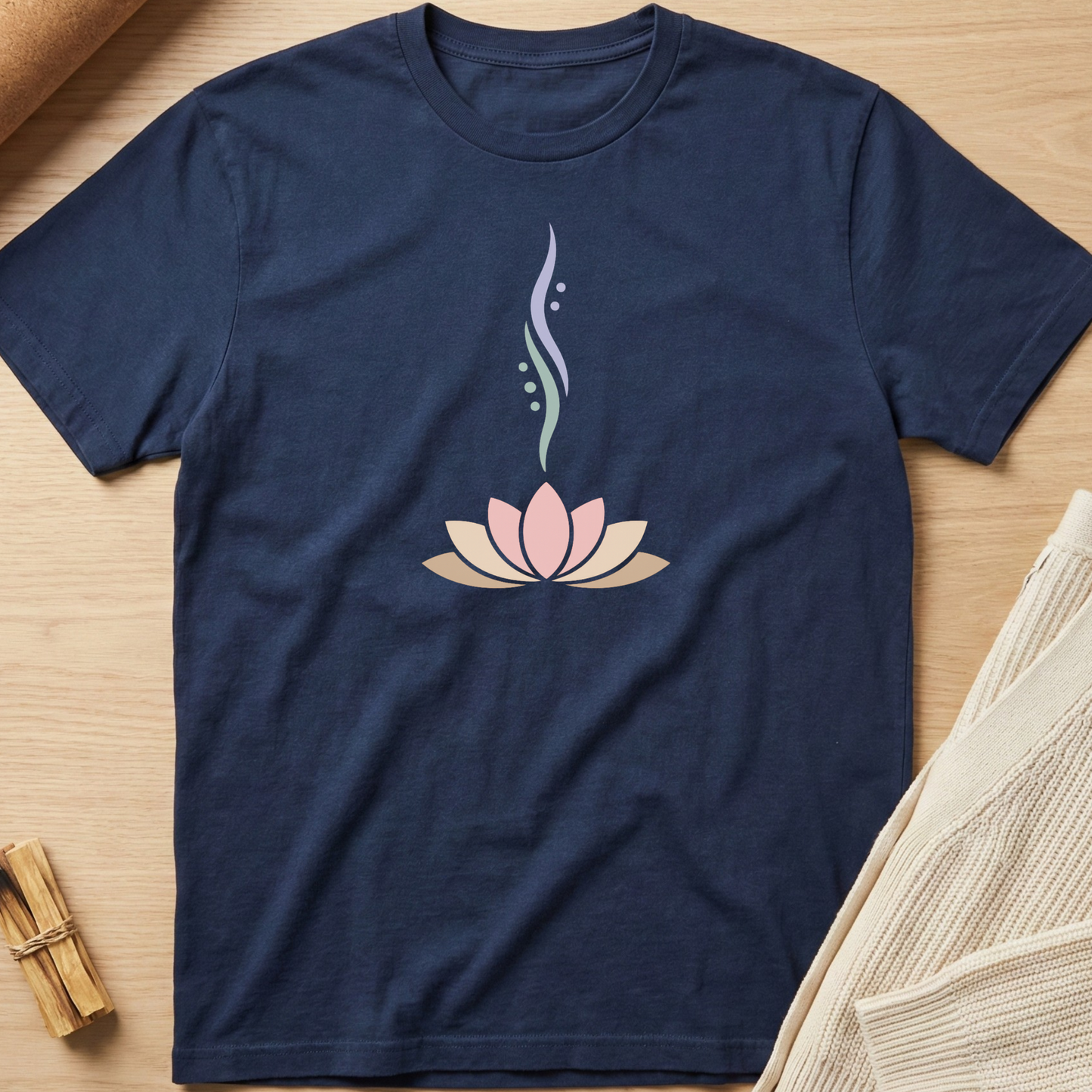 Navy blue t-shirt with a pink lotus flower design on a wooden surface. Minimalist yoga apparel by pemuyo.