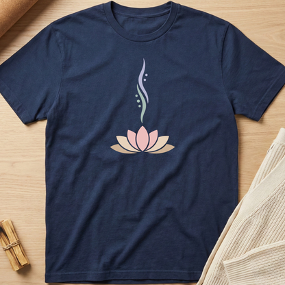 Navy blue t-shirt with a pink lotus flower design on a wooden surface. Minimalist yoga apparel by pemuyo.