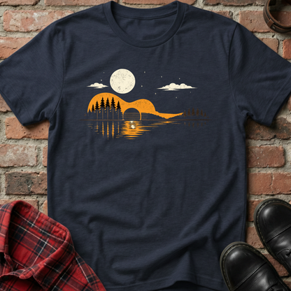 Navy blue t-shirt with a graphic design of a mountain, trees, and moon on a brick background. Minimalist music apparel by pemuyo.