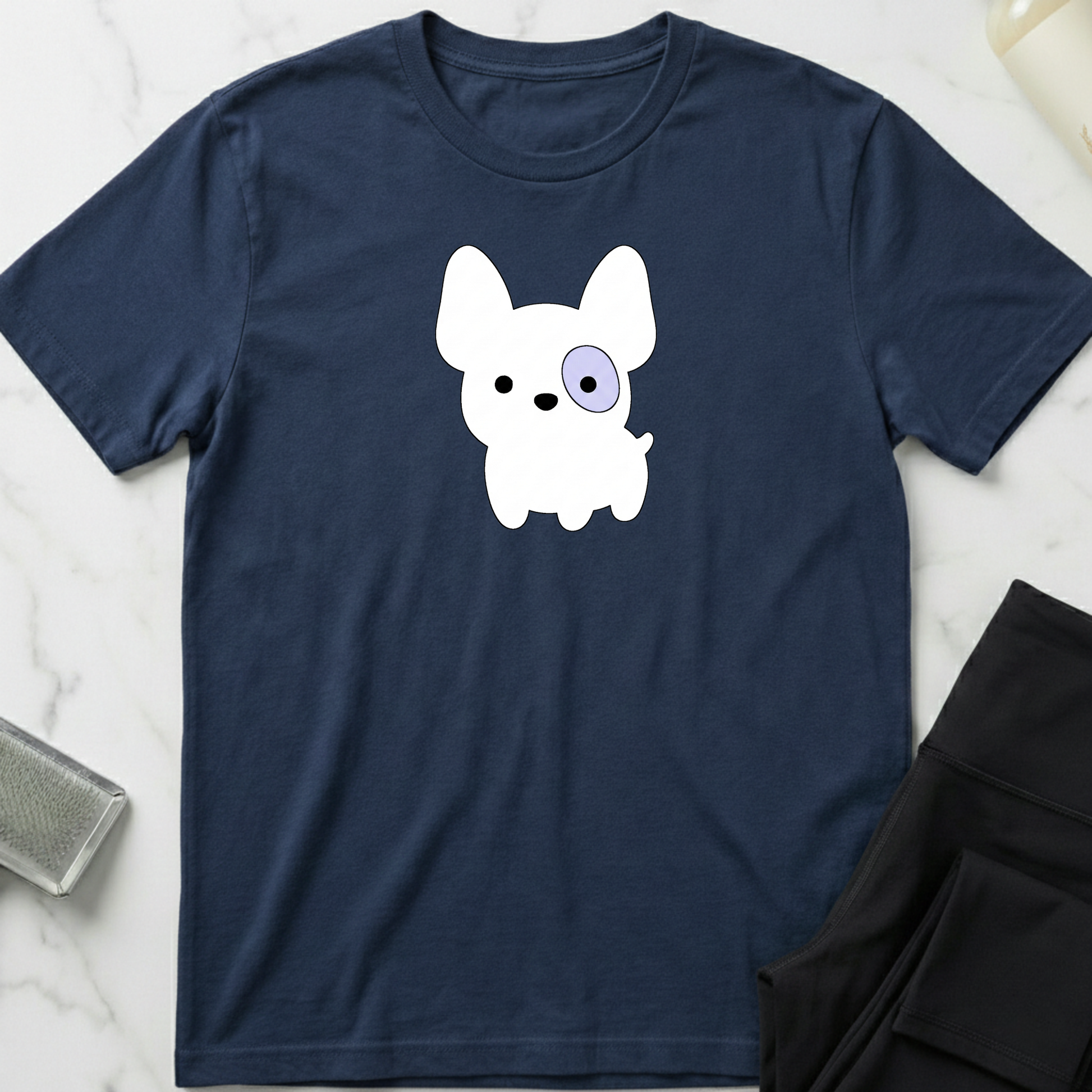Navy blue t-shirt with a white dog graphic on a marble surface. Minimalist dog apparel by pemuyo.