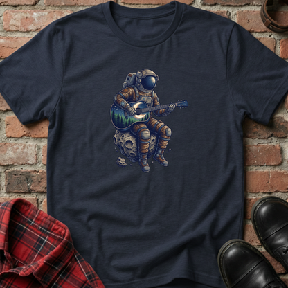 Navy blue t-shirt with an astronaut playing guitar graphic on a brick wall background. Minimalist music apparel by pemuyo.