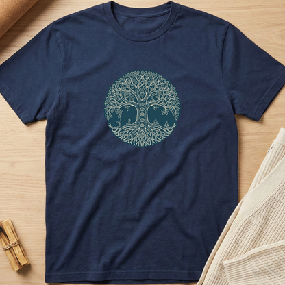 A navy blue short-sleeve crewneck t-shirt with a circular tree of life graphic made from elephant silhouettes in the center, laid flat on a light wood background with neutral props. Minimalist yoga apparel by pemuyo.