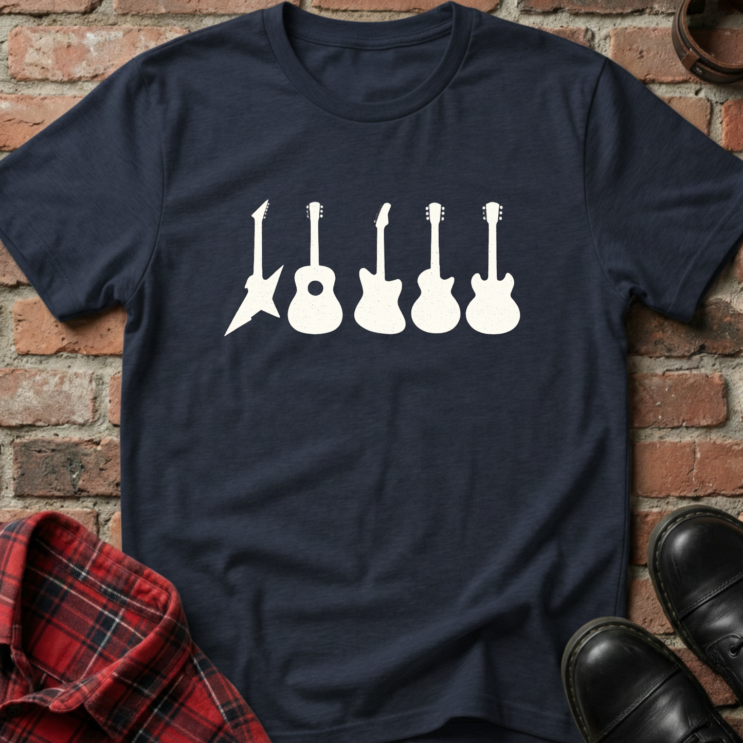 Navy blue t-shirt with white guitar graphic on a brick background. Minimalist music apparel by pemuyo.
