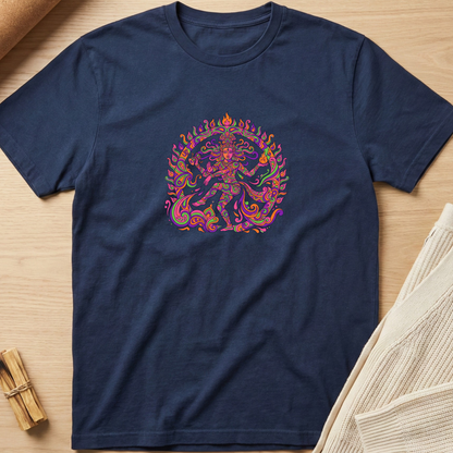 A navy blue short-sleeve t-shirt with a colorful, psychedelic-style graphic of a dancing deity in the center, laid flat on a light wood background with neutral props. Minimalist yoga apparel by pemuyo.