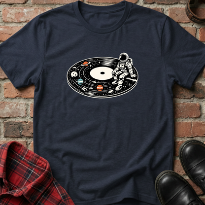 Navy blue t-shirt with an astronaut on a vinyl record design, placed against a brick wall. Minimalist music apparel by pemuyo.