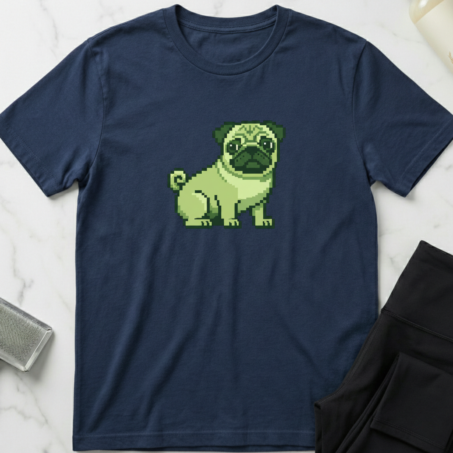 Navy blue t-shirt with a pixelated green pug design on a marble surface. Minimalist dog apparel by pemuyo.