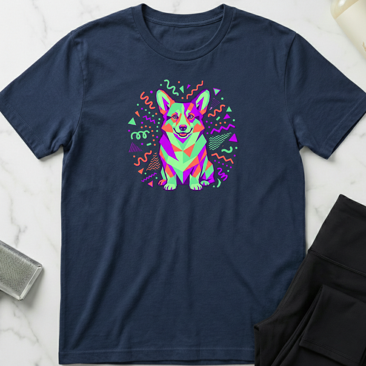Navy blue t-shirt with a colorful corgi graphic on a marble surface. Minimalist dog apparel by pemuyo.