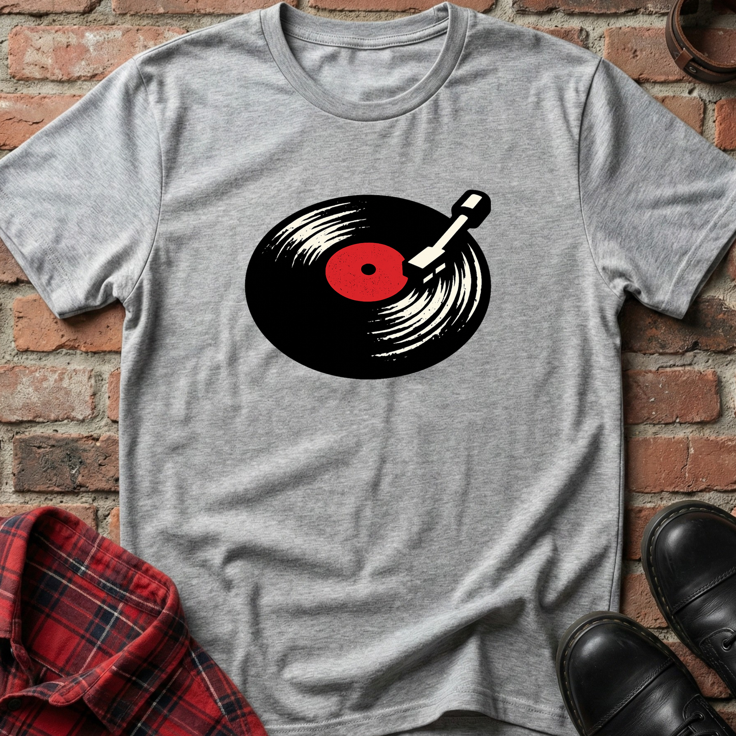 Gray t-shirt with a vinyl record graphic on a brick wall background. Minimalist music apparel by pemuyo.