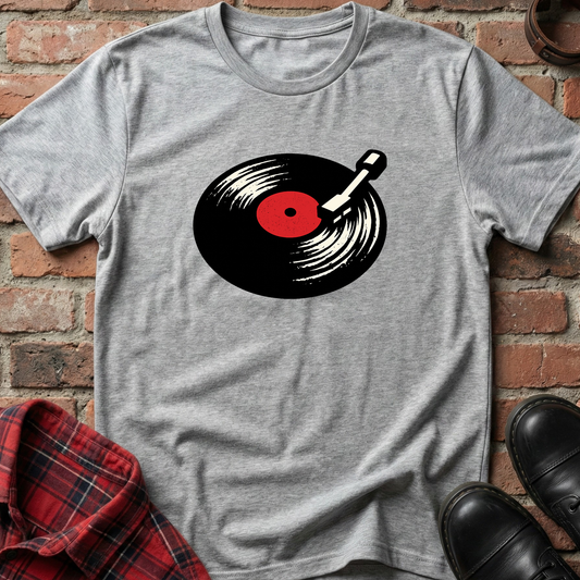Gray t-shirt with a vinyl record graphic on a brick wall background. Minimalist music apparel by pemuyo.