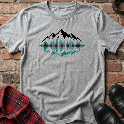 Gray t-shirt with mountain graphic on a brick surface. Minimalist music apparel by pemuyo.