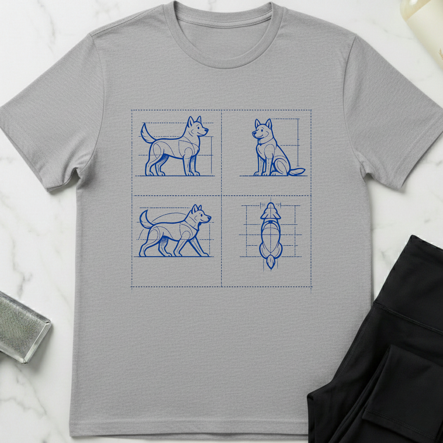 Gray t-shirt with blue dog illustrations on a white marble surface. Minimalist dog apparel by pemuyo.