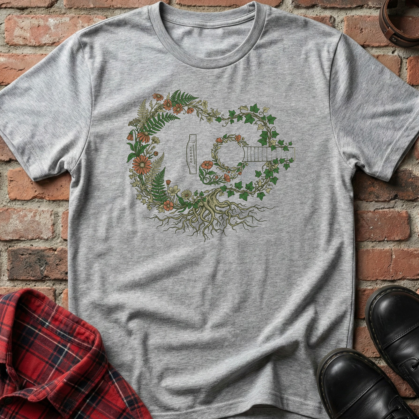 Gray t-shirt with a guitar and floral design on a brick surface. Minimalist music apparel by pemuyo.