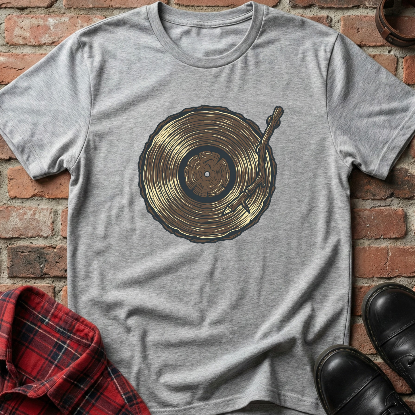 Gray t-shirt with a vinyl record design on a brick background. Minimalist music apparel by pemuyo.