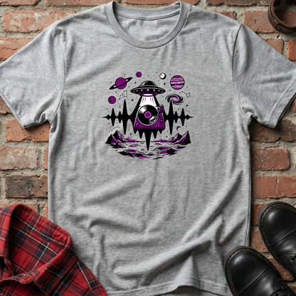 Gray t-shirt with alien spaceship graphic on a brick wall background. Minimalist music apparel by pemuyo.
