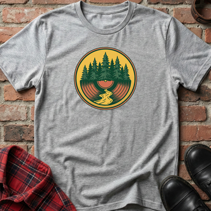 Gray t-shirt with a graphic design of trees and a person on a vinyl record against a brick wall. Minimalist music apparel by pemuyo.