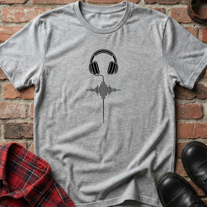 Gray t-shirt with headphones and sound wave design on a brick background. Minimalist music apparel by pemuyo.